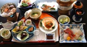 a table with plates of food and bowls of food at Hotel New Katsura in Sado