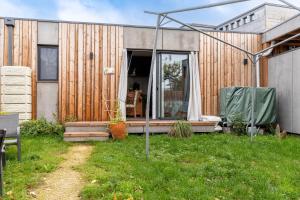 a home with a wooden facade and a patio at O Petit Jardin in Cholet