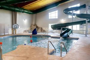 a indoor swimming pool with a slide in a building at Country Inn & Suites by Radisson, Prairie du Chien in Prairie du Chien