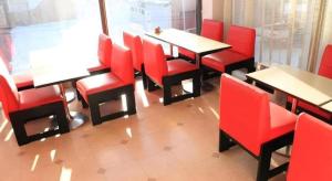 函館市にあるHotel Kikuyaの赤い椅子とテーブルのあるレストランのダイニングルーム