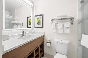 a white bathroom with a sink and a toilet at MainStay Suites Raleigh North in Raleigh +25 photos