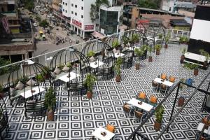 Un balcón con mesas y sillas en una calle de la ciudad. en Hotel Galaxy, en Jodhpur