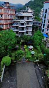 PokharaにあるHotel Lake Palaceの傘と木々のある建物の航空写真