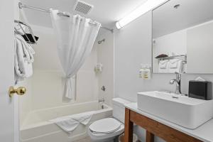 a white bathroom with a sink and a tub and a toilet at Country Inn & Suites by Radisson, Saskatoon, SK in Saskatoon +59 photos