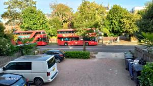 a parking lot with two red buses and cars at Espaço Realeza in London