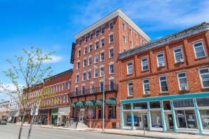 a large red brick building on a street at Tygart Hotel, an Ascend Collection Hotel in Elkins