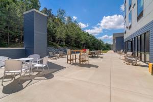 a patio with tables and chairs next to a building at Cambria Hotel & Suites Plymouth in Plymouth
