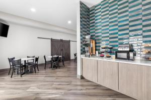 a dining room with a counter and tables and chairs at Brentwood Suites Nashville, an Ascend Collection Hotel in Brentwood