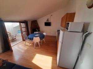 a kitchen and dining room with a refrigerator and a table at Appartement à 300 m de la mer in Nughedu Santa Vittoria