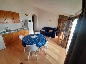 a kitchen with a table and chairs in a room at Appartement à 300 m de la mer in Nughedu Santa Vittoria