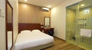 a bedroom with a bed and a glass shower at Elegant Hotel in Kampong Linau