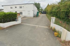 a driveway in front of a white house at Studio avec place de parking in Veigné