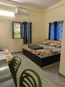 a bedroom with two beds and chairs and a table at Nature Homestay in Varanasi
