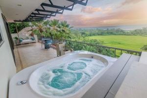 エステリリョスにあるVilla Maralaの家のバルコニーにあるジャグジー浴槽