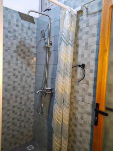 コトヌーにあるEntré personnelle à fidjrosseのバスルーム(シャワー、シャワーカーテン付)が備わります。