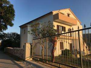 Biały dom za płotem z bramą w obiekcie Apartments Simurina w mieście Vlašići