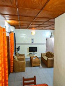 コトヌーにあるEntré personnelle à fidjrosseのソファ2つとテレビのあるリビングルーム +3枚の写真