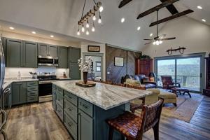 a kitchen with green cabinets and a living room at The Owlery in Highlands