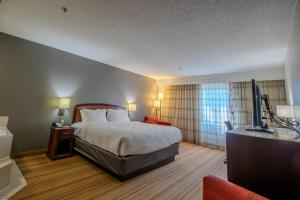 a hotel room with a bed and a flat screen tv at Country Inn & Suites by Radisson, Convention Center in Altoona