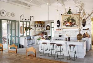 a kitchen with a white counter and bar stools at Noois’hof Sinclair Nature Reserve in Helmeringhausen