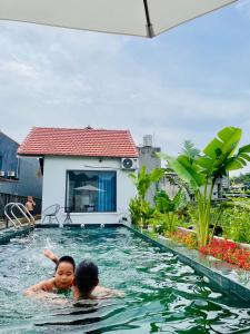 deux enfants nageant dans une piscine dans l'établissement Tam Coc Hope House, à Ninh Binh