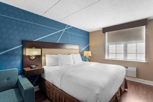 une chambre d'hôtel avec un grand lit et une chaise dans l'établissement Comfort Inn & Suites Pottstown Eastern Gateway, à Pottstown 76 autres photos