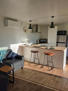 een woonkamer met een bank en een keuken bij Forest View Farm Stay in Pirongia