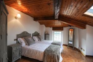 a bedroom with a large bed and a wooden ceiling at Cà Lisa in San Fedele Intelvi