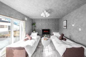 - une chambre avec 2 lits, une cheminée et une télévision dans l'établissement Sasameyuki, à Furano