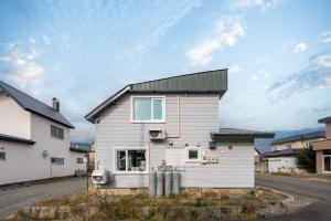 une maison blanche avec un toit noir dans l'établissement Sasameyuki, à Furano