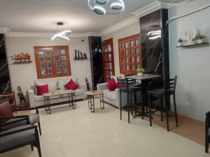 Una sala de estar con un sofá, una mesa y sillas. en Bonne Vie Studios, en Seis de Octubre