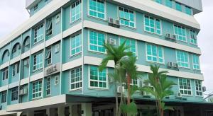 a blue building with palm trees in front of it at 900 Inn in Bintulu
