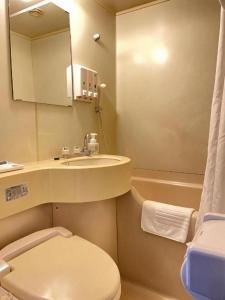 um banheiro com vaso sanitário, pia e banheira em Marroad Inn Tokyo em Fuchu