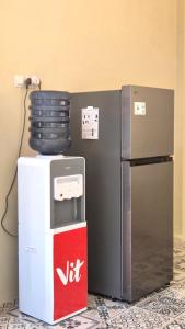 Un refrigerador y una caja de bebidas junto a un contenedor en Sesare Living by Calli Rooms, en Wirolegi