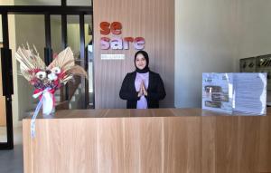 una mujer parada detrás de un mostrador en una oficina en Sesare Living by Calli Rooms, en Wirolegi