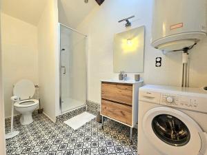 Un baño con lavadora y un inodoro. en Perchoir Riboud - Coeur de ville, en Bourg-en-Bresse