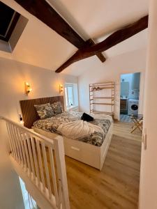 Un dormitorio con una cama y suelo de madera. en Perchoir Riboud - Coeur de ville, en Bourg-en-Bresse