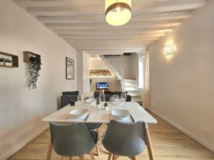 Un comedor con una mesa y sillas blancas. en Perchoir Riboud - Coeur de ville, en Bourg-en-Bresse 16 fotos más
