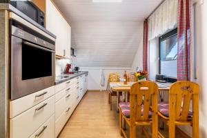 a kitchen with a table and a dining room at Ferienwohnung Luri in Gangelt +24 photos