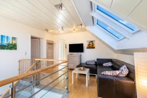 a living room with a black couch and a tv at Ferienwohnung Luri in Gangelt