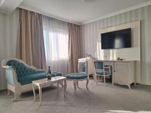 a living room with a couch and chairs and a table at Hotel Roman by Dumbrava Business Resort in Roman +38 photos