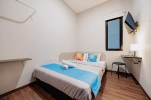 a bedroom with a bed with a teddy bear on it at Sans Stay Bintaro in Pondoklang +30 photos