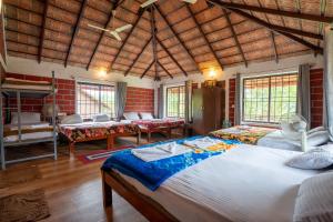 a bedroom with two beds in a room with windows at Streamedge Sakleshpur in Hanbalu +143 photos
