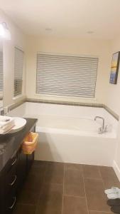 a bathroom with a white tub and a sink at Private Derbyshire Guest Suite in Coquitlam