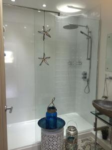 uma casa de banho com um chuveiro e um vaso azul em Ocean Drive Deluxe Apartment ground floor Brean with a complimentary Tray em Brean