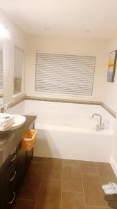 a white bathroom with a tub and a sink at Vancouver loves you in Coquitlam