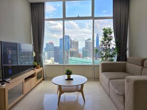 クアラルンプールにあるSky Suites KLCC By Tomのソファと大きな窓のあるリビングルーム