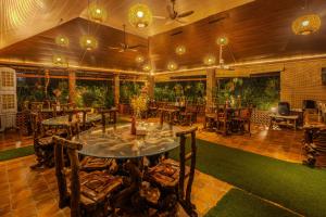a restaurant with a table and chairs in a room at Streamedge Sakleshpur in Hanbalu