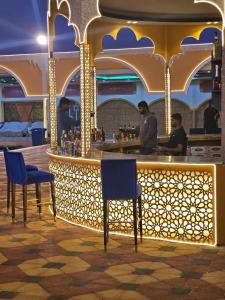 a bar on a cruise ship with blue chairs and people at Desert Safari Dubai Over Night Stay in Hunaywah