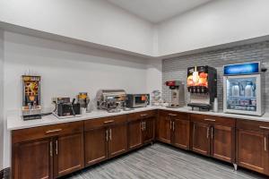 a large kitchen with wooden cabinets and a refrigerator at Comfort Suites Hattiesburg near University in Hattiesburg